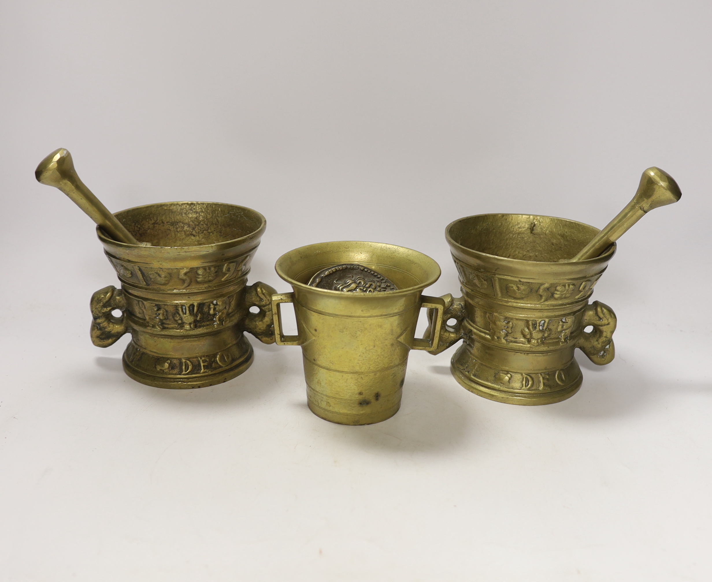 Three bronze / brass mortars and two pestles and a medallion